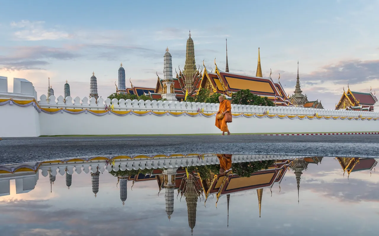วัดพระศรีรัตนศาสดาราม (วัดพระแก้ว) หลังกำแพงพระบรมมหาราชวัง สะท้อนเงาในแอ่งน้ำบนลานด้านหน้า