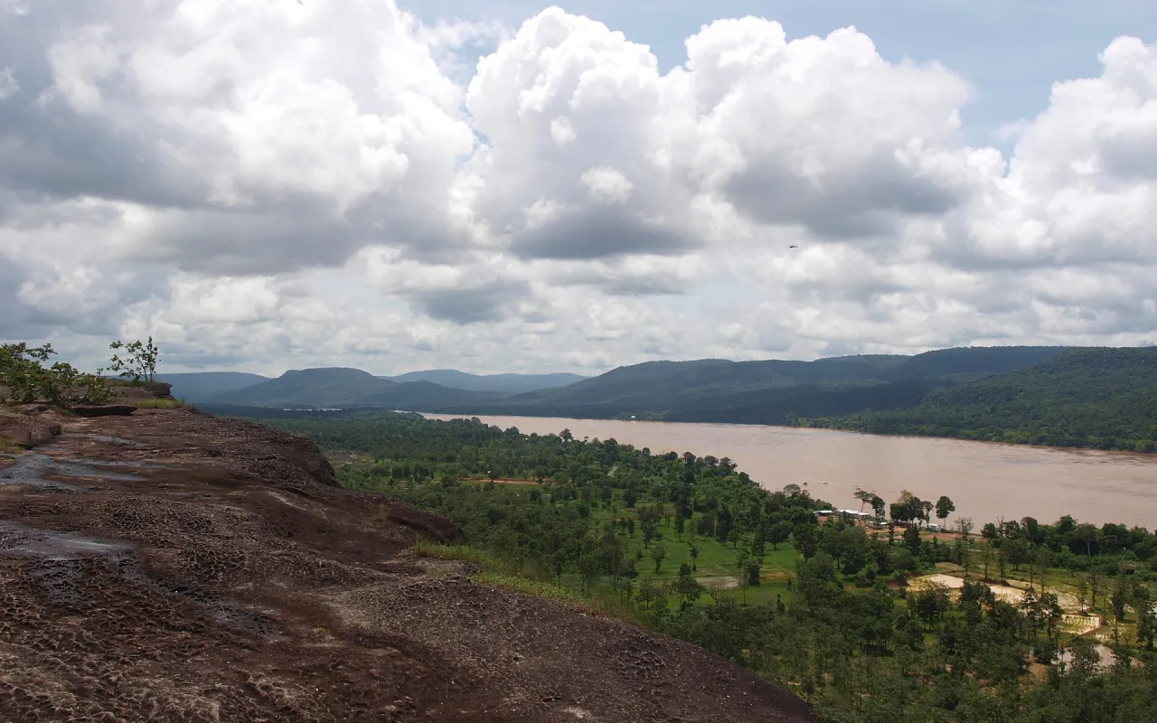 ลานหินบนหน้าผาอุทยานแห่งชาติผาแต้ม มองเห็นแม่น้ำโขงและทิวเขาฝั่งลาวใต้ท้องฟ้าเมฆขาว