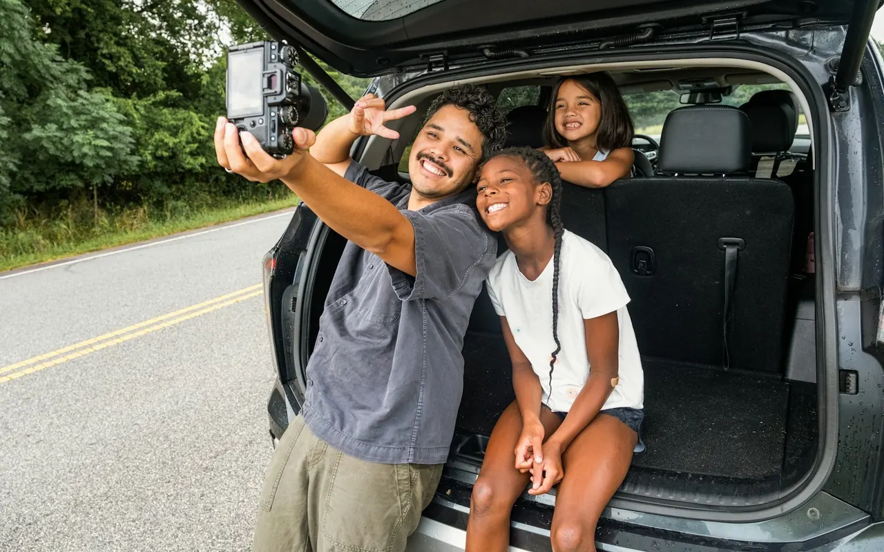 พ่อและลูกถ่ายเซลฟีที่ท้ายรถ SUV ระหว่างเดินทาง